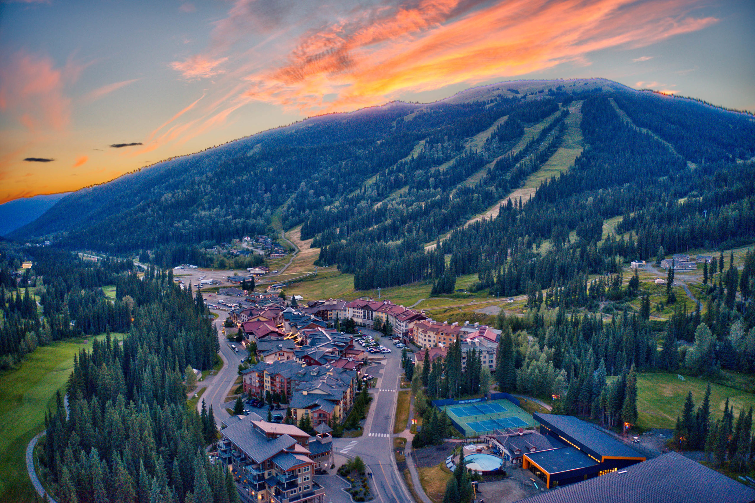 aerial view looking over sun peaks village and Tod Mountain with whispy clouds during the sunset
