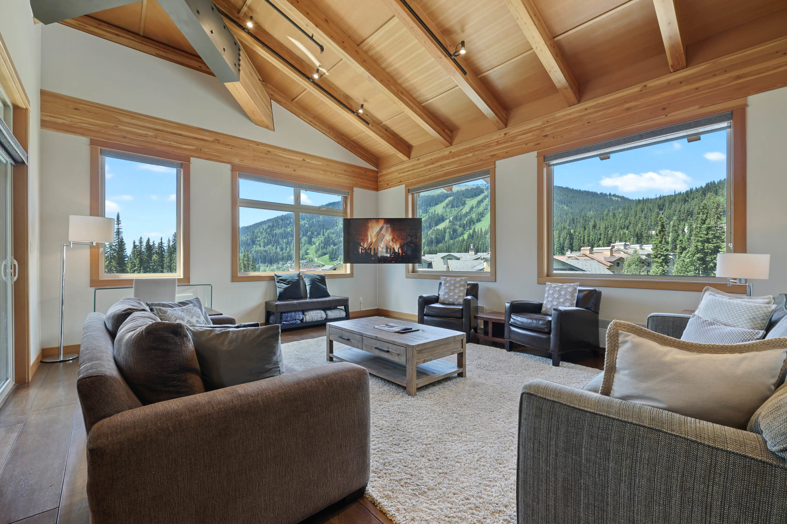 Lounge in the kookaburra 405 unit with sofas surrounding a coffee table and windows looking out at Tod Mountain